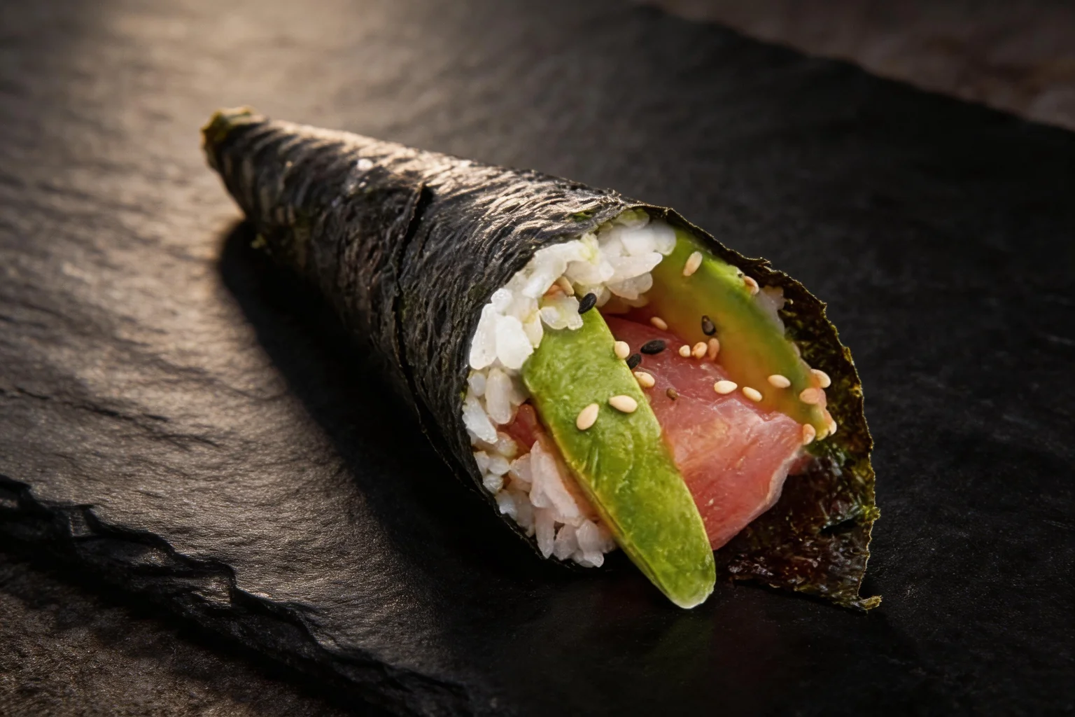 Témaki thon avocat sur ardoise sombre.